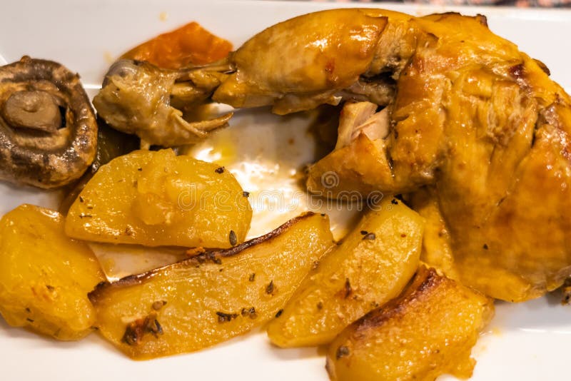 Roast Chicken Thigh with Potatoes and Mushrooms on a White Plate Stock