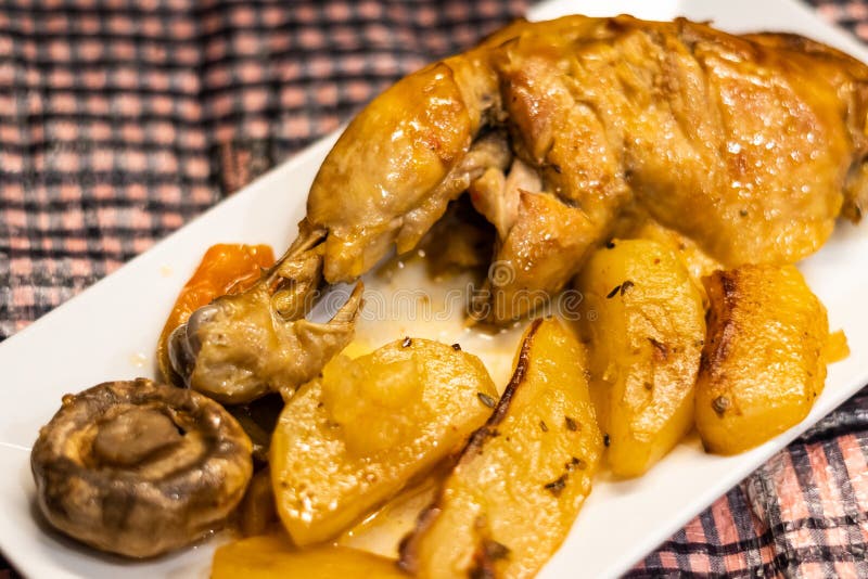 Roast Chicken Thigh with Potatoes and Mushrooms on a White Plate Stock