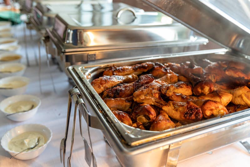 Roast Chicken Thighs in a Warming Pot on a Catering Table Stock Photo