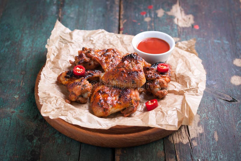 Roasted barbecue chicken wings with bbq sauce, italian herbs, olive oil and pepper