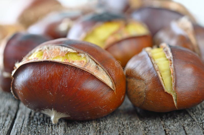 Excelente horneado castanas sobre el viejo de madera mesa.