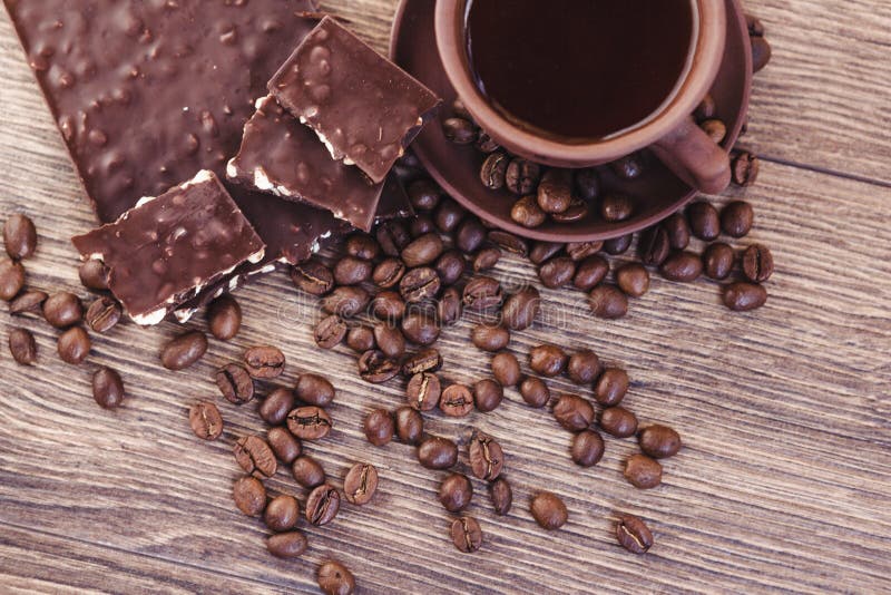 Roasted Coffee Beans with Chocolate and Nuts on a Wooden Surface. Stock