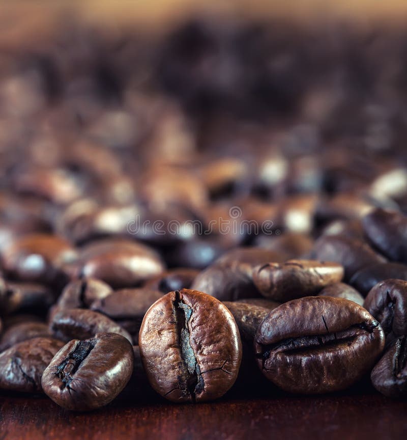 Roasted Coffee Beans Spilled Freely on a Wooden Table. Coffee Beans in