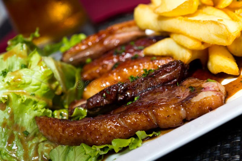 Roasted duck with french fries, potatoes, caramelized, and Salad