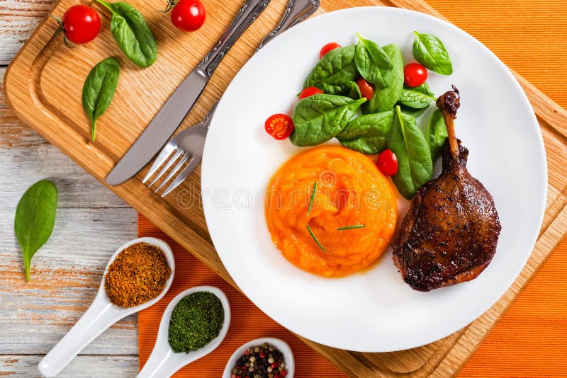 Roasted duck leg with mashed pumpkin and salad stock photography Roasted duck leg with mashed pumpkin and salad stock photography