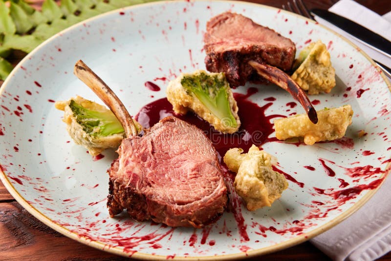 Lamb with Berry Sauce on Round Plate on White Background. Stock Image