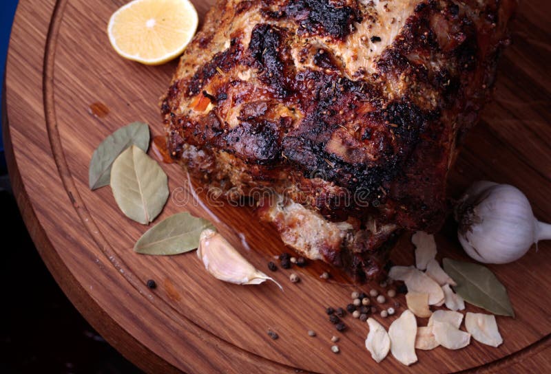 Roasted meat on wooden cutting board closeup