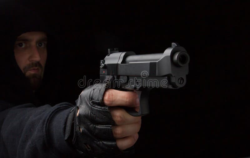 Robbery in store. Robber is aiming and threatening with gun in shop. Stock  Photo