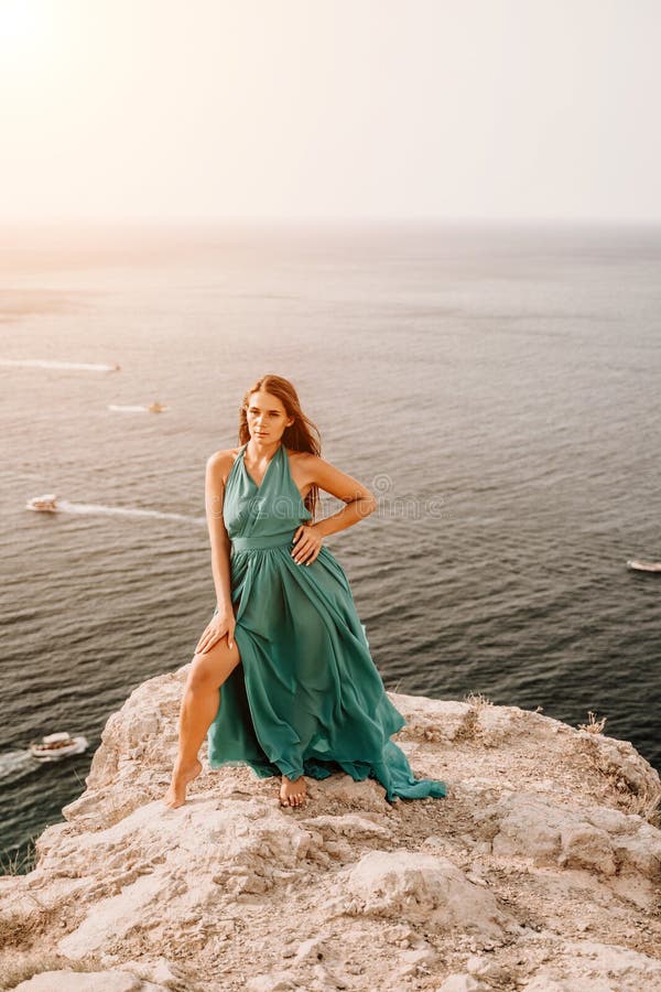 Robe verte pour femme sea trevel. vue latérale une femme heureuse aux cheveux longs en robe de menthe longue posant sur une plage photos stock