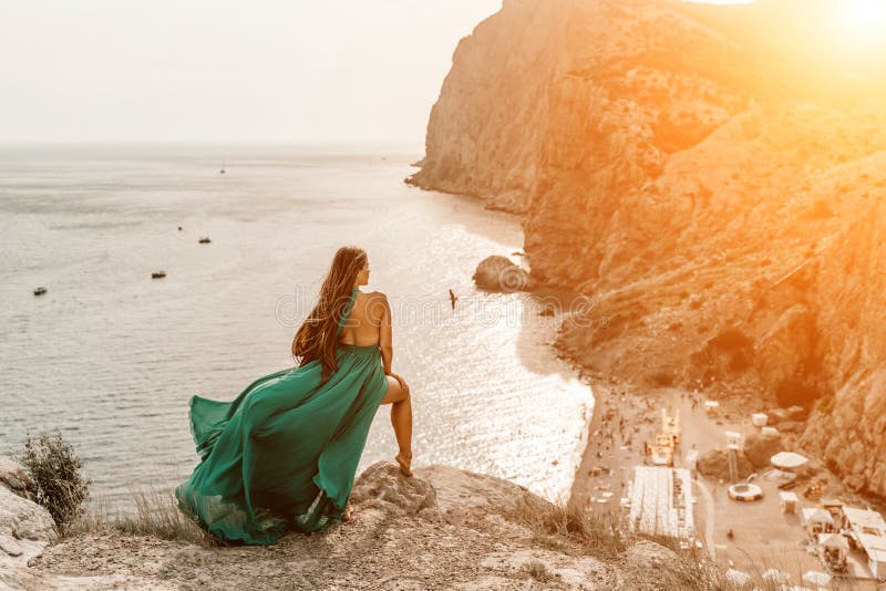 Robe verte pour femme sea trevel. vue latérale une femme heureuse avec des cheveux longs en robe de menthe longue posant sur une p photographie stock libre de droits