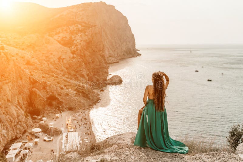 Robe verte pour femme sea trevel. vue latérale une femme heureuse avec des cheveux longs en robe de menthe longue posant sur une p photo libre de droits