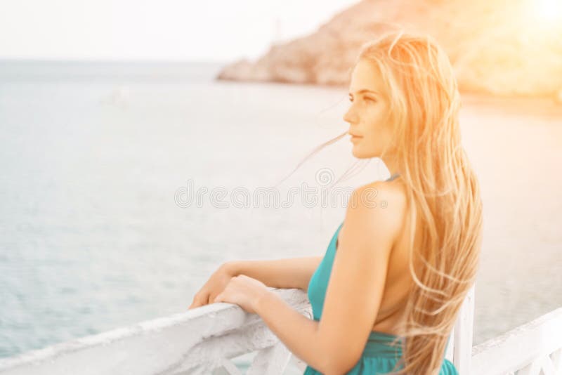 Robe verte pour femme sea trevel. vue latérale une femme heureuse avec des cheveux longs en robe de menthe longue posant sur une p photographie stock libre de droits