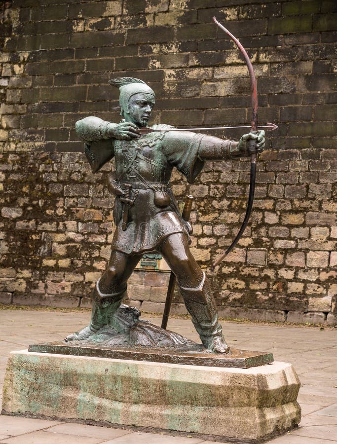 Statue of the legendary outlaw Robin Hood standing on a plinth outside the castle wall in Nottingham, England.