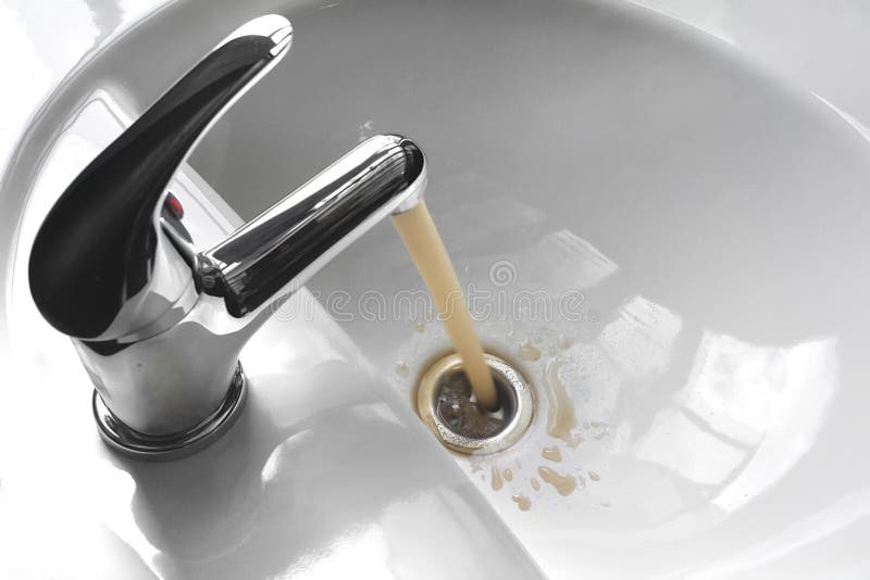 Robinet d'eau avec courir Muddy Water sale dans un évier photographie stock Robinet d'eau avec courir Muddy Water sale dans un évier photographie stock