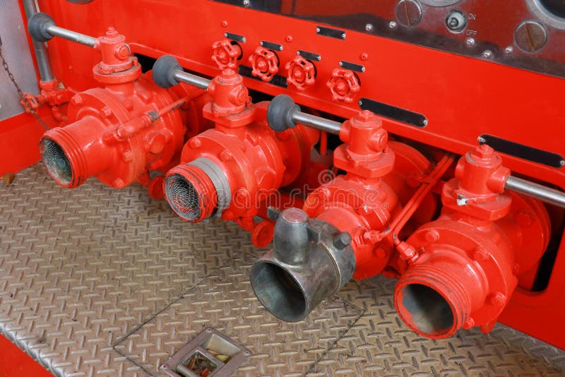Robinets de tuyau de camion de pompiers de pompier en rouge et un argent de rangée images stock Robinets de tuyau de camion de pompiers de pompier en rouge et un argent de rangée images stock