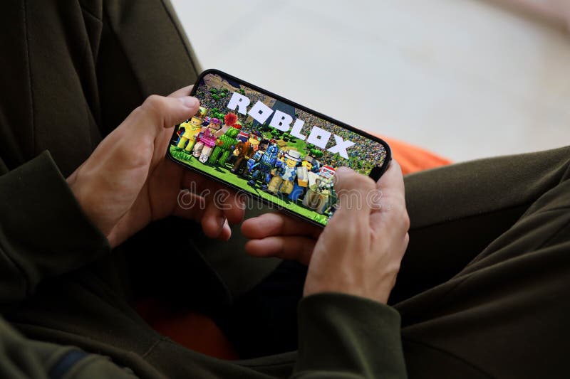 Person holding smartphone with website of US video games company Roblox  Corporation on screen in front of logo. Focus on center of phone display  Stock Photo - Alamy