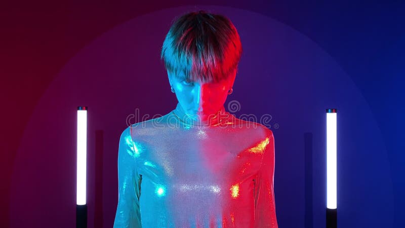Robot androide femmina che accende un sorriso artificiale al neon illuminato al chiuso stock footage
