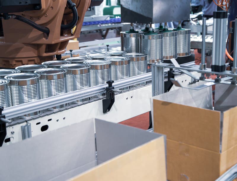 Automation robot lifting food can into cardboard in production line. Food industry