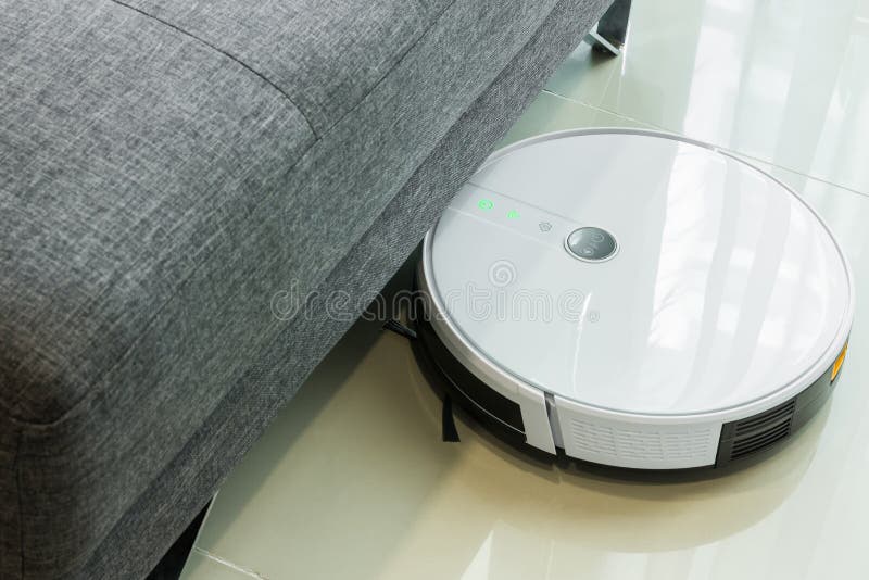 Robotic Vacuum Cleaner Cleaning the Floor Under the Sofa Stock Image