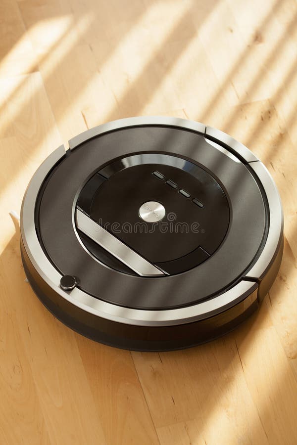 Robotic Vacuum Cleaner on Laminate Wood Floor Smart Cleaning Tec Stock