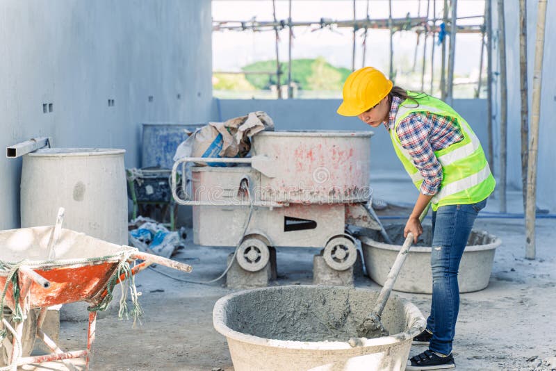 Robotnica pracownicza pracująca w mieszance betonowej roboty twarde na budowie zdjęcie stock