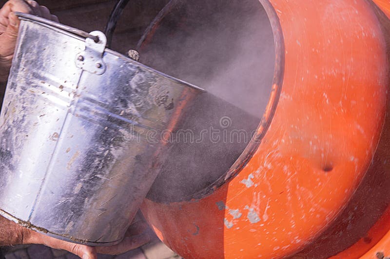 Robotnik wlewający suchy cement w beton Mieszarka popielana proces budowy z pyłem zdjęcia royalty free