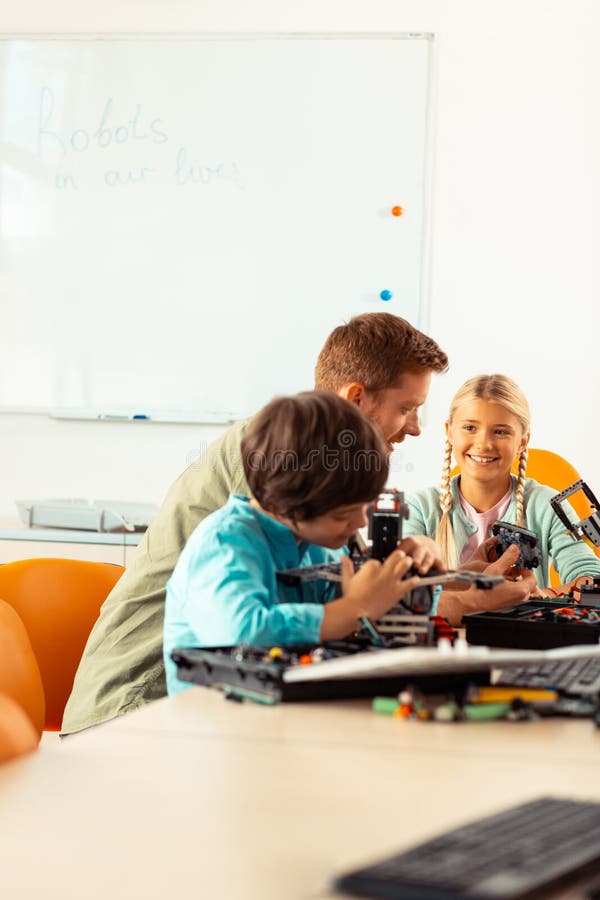 Teacher showing his pupils ways of building robots. royalty free stock photos