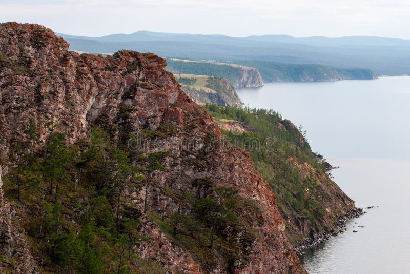 Rocas rojas hermosas en la orilla del lago Baikal en la isla de Olkhon imagen de archivo libre de regalías Rocas rojas hermosas en la orilla del lago Baikal en la isla de Olkhon imagen de archivo libre de regalías