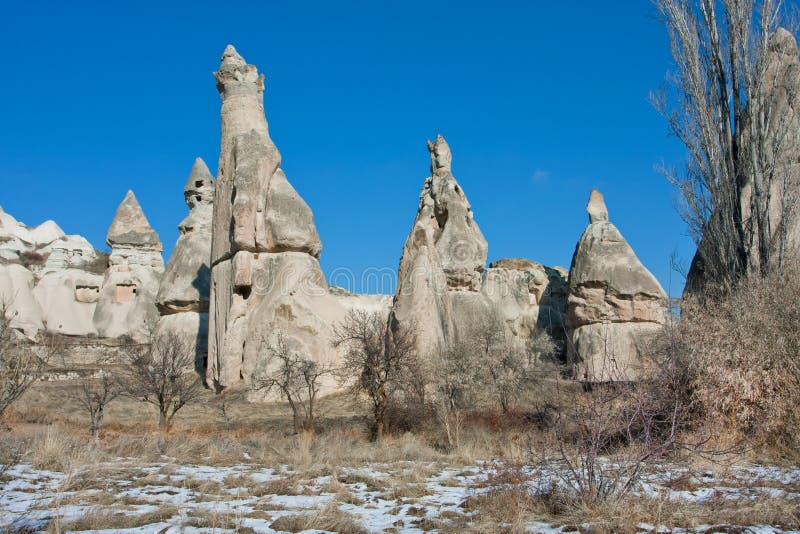 Rocce a forma di cono in una valle della montagna con erba asciutta e gli alberi immagine stock libera da diritti Rocce a forma di cono in una valle della montagna con erba asciutta e gli alberi immagine stock libera da diritti