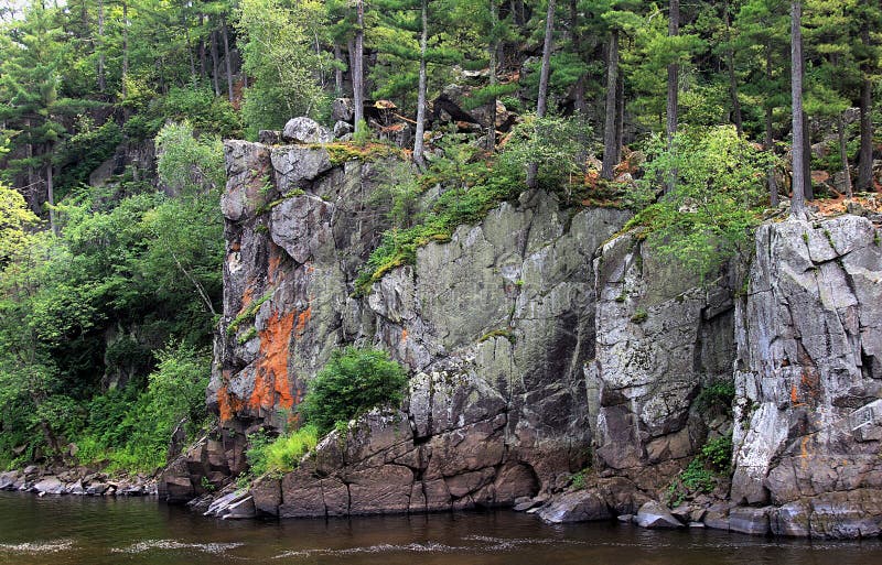 Rochas e floresta no banco no rio de Minnesota imagens de stock Rochas e floresta no banco no rio de Minnesota imagens de stock