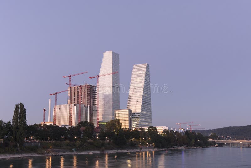 Roche headquarters in Basel, Switzerland by Rhine river. Swiss global pharma company buildings. Urban skyline of the city, sunset