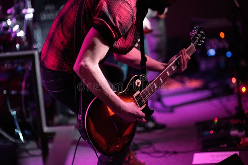 Rock band performs on stage. Guitarist, bass guitar and drums. The guitarist plays royalty free stock images Rock band performs on stage. Guitarist, bass guitar and drums. The guitarist plays royalty free stock images