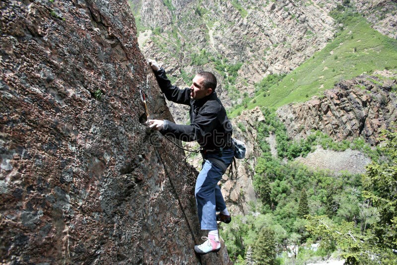 Rock climber clipping bolt