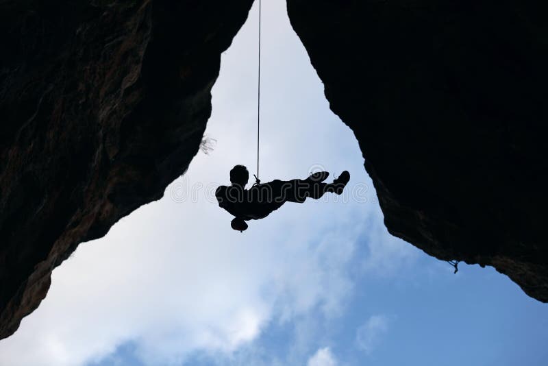 Rock climber going down from the top of route