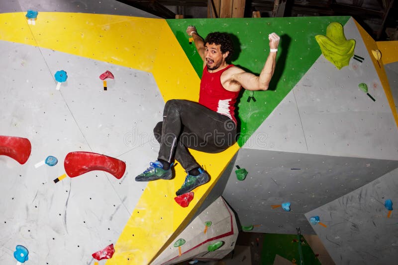 Rock Climber Man Hanging on a Bouldering Climbing Wall, Inside on