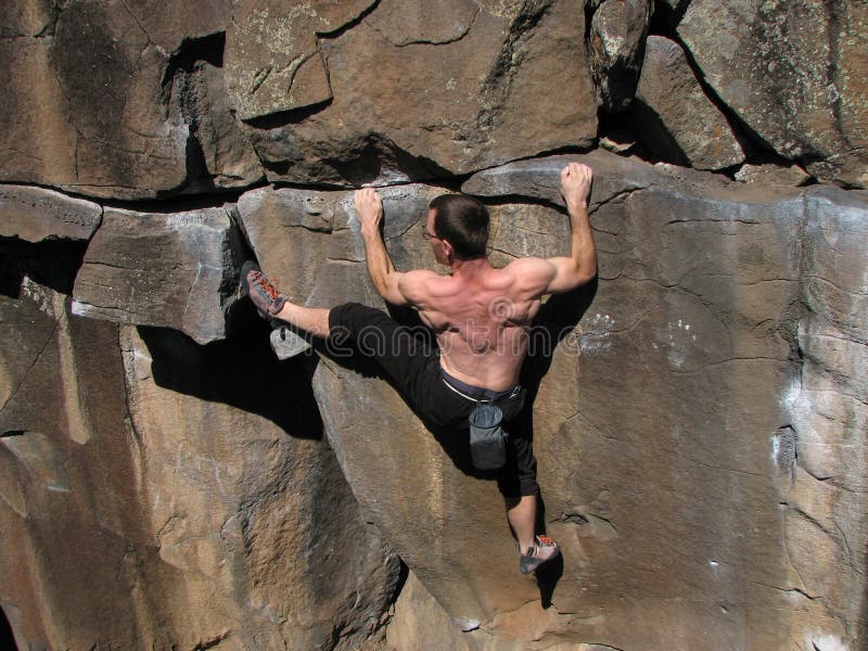 Klettern-ein Mann ohne Seil Stämme zu erklimmen.
