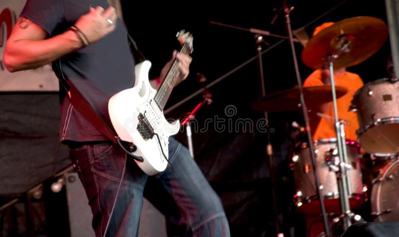 Guitarist and drummer at rock concert. Some noise and motion blur.