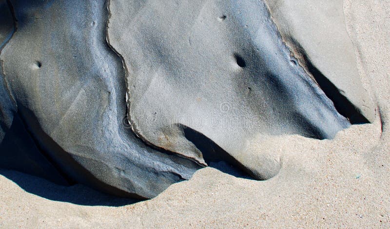 Rock formation in sand in Laguna Beach, California.