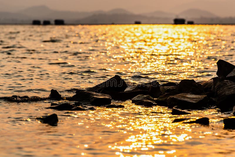 Rock in the water sunlight reflect the yellow glow