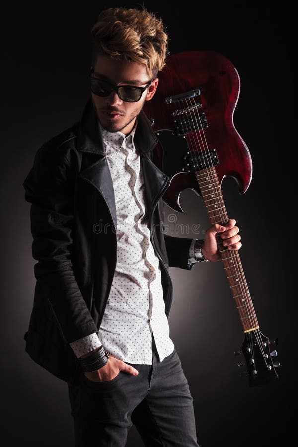 Rocker Holding His Guitar on Shoulder and Looking Back Stock Photo