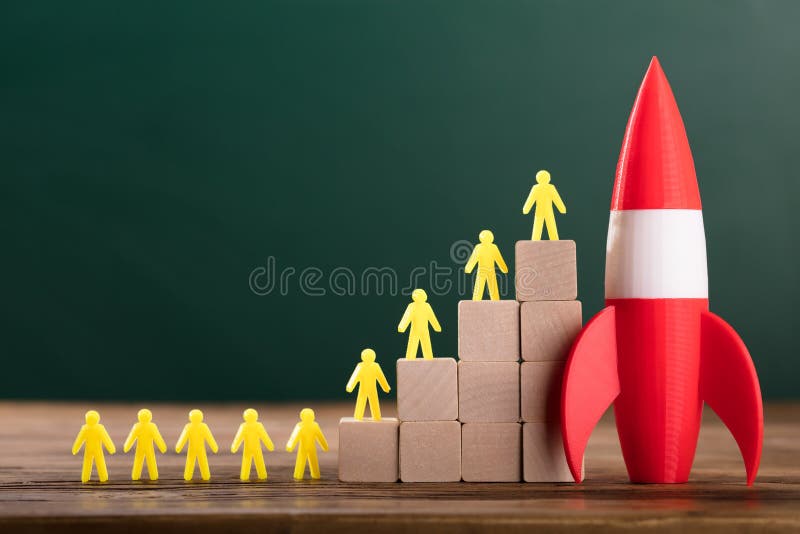 Rocket Besides Yellow Human Figures encima de bloques de madera imagen de archivo libre de regalías Rocket Besides Yellow Human Figures encima de bloques de madera imagen de archivo libre de regalías