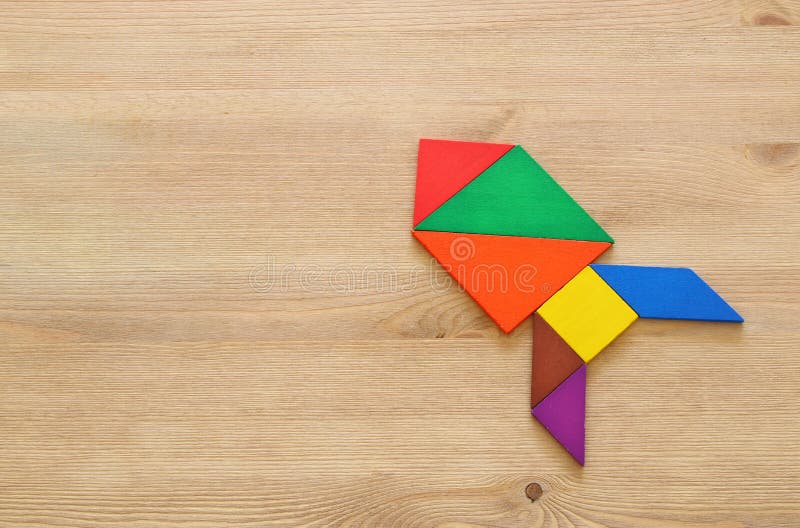 Rocket made from tangram puzzle on blue pastel wooden background. royalty free stock image
