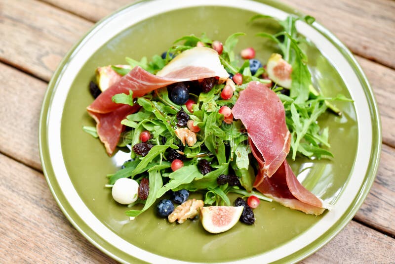 Rocket salad with prosciutto parma ham and berries fruit, Healthy diet food full of good vegetable and nutrition