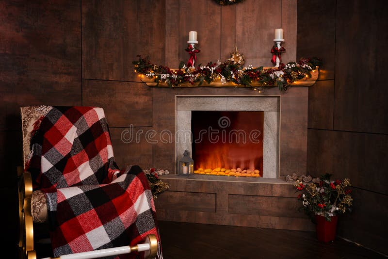 Rocking Chair in the Living Room with Decorated Flaming Fireplace Stock