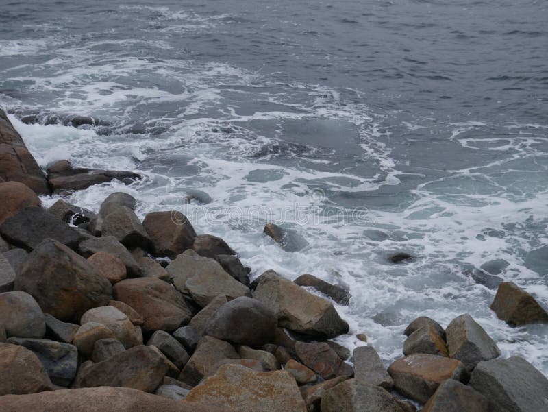 Rockor med hav som kraschar mot den royaltyfria bilder