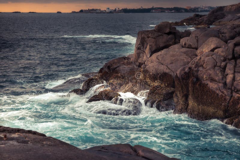 Rocky beach with sea waves crashing on the rocks and dramatic sunset sky scenery in Sri Lanka stock photos Rocky beach with sea waves crashing on the rocks and dramatic sunset sky scenery in Sri Lanka stock photos