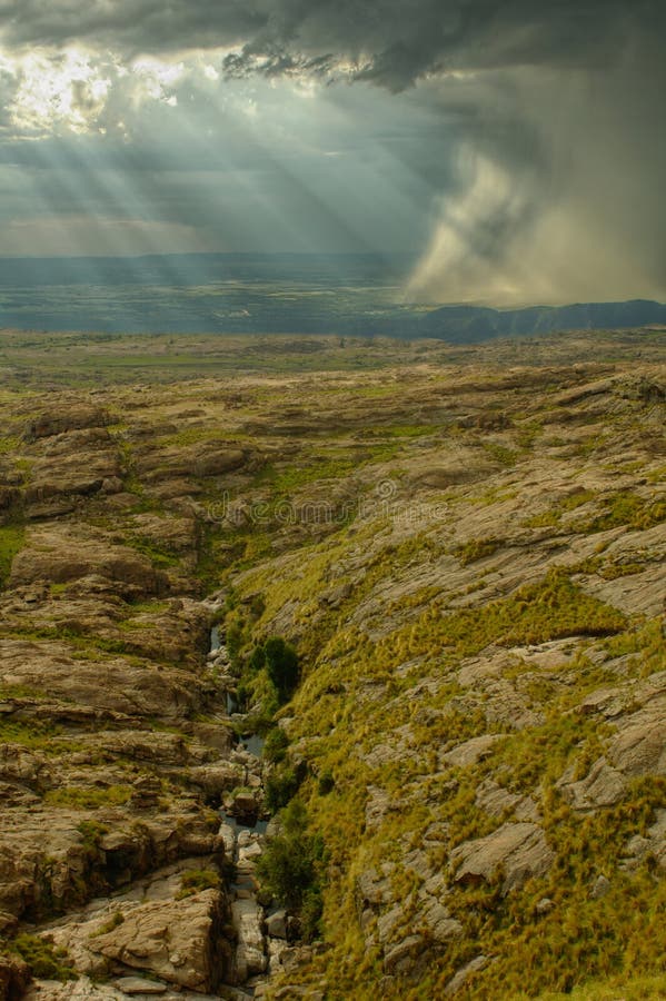 Rocky hill with heavy storm and creek