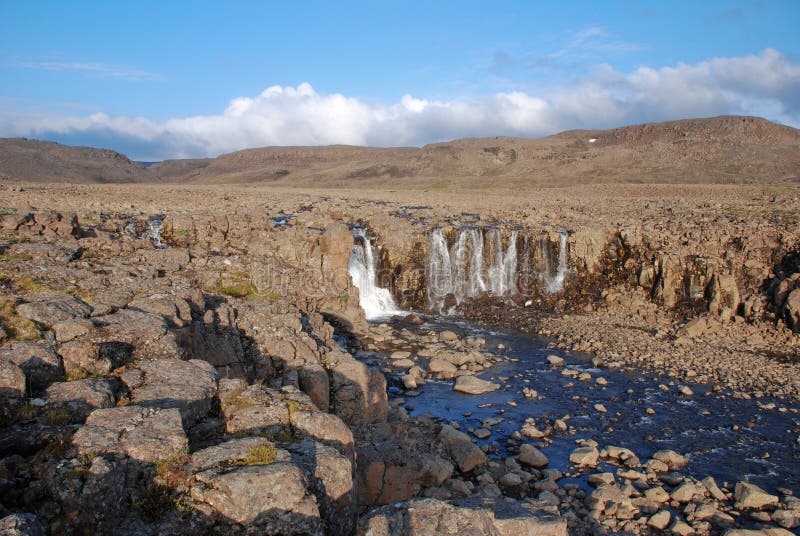 A rocky landscape with a waterfall.