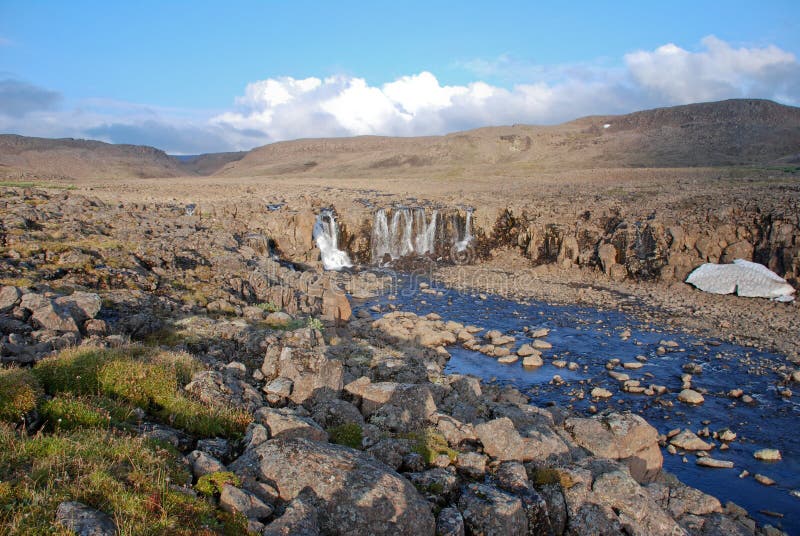 A rocky landscape with a waterfall.