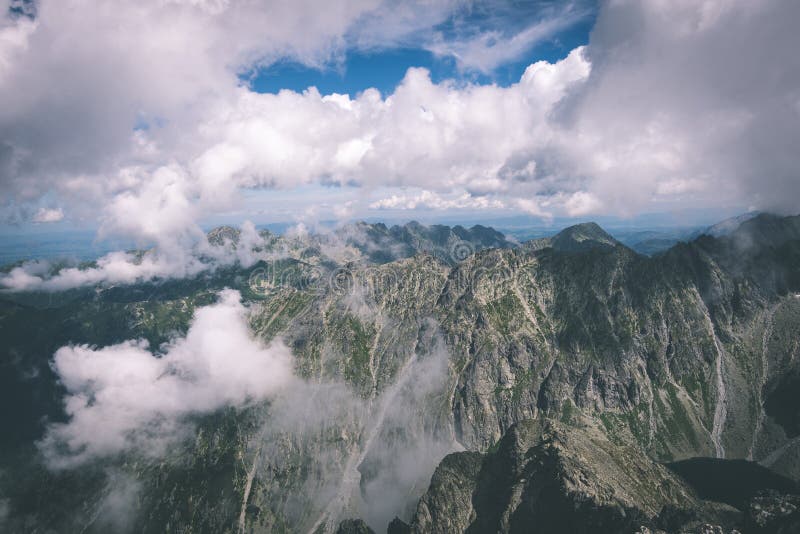 Rocky mountain landscape covered with clouds - vintage film effect